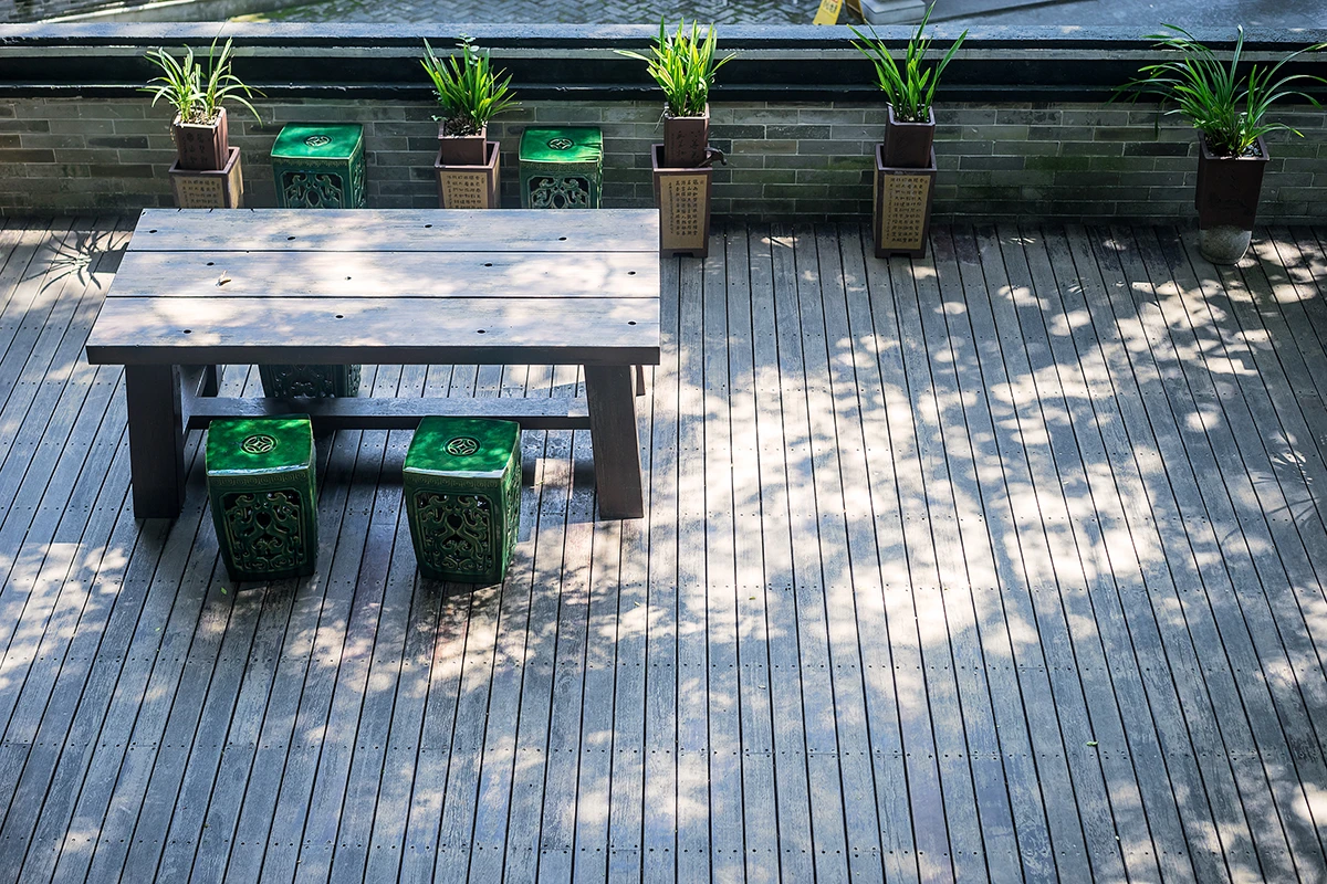 Custom deck builds in Havelock featuring minimalist wood design and green garden stools