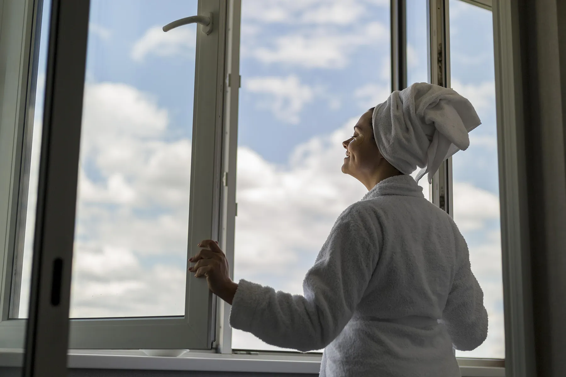 Homeowner enjoying fresh air after Renossance service — comfort and performance justify the cost of window installation.
