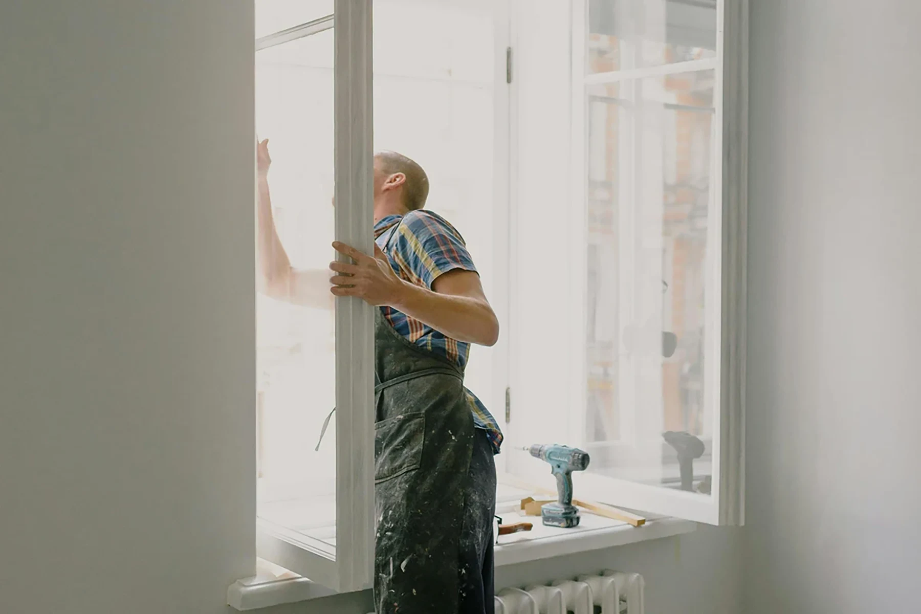Renossance installer fitting a new energy-efficient unit during professional window repair or replacement.