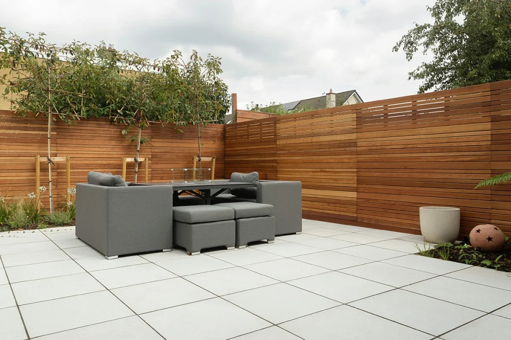 Modern backyard with horizontal wooden slat fence and minimalist patio furniture, showing popular minimalist fence styles in Ontario.
