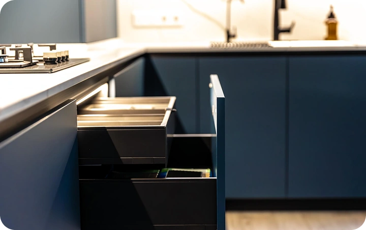 Modern kitchen with navy blue cabinets and open pull-out drawers — custom kitchen cabinet installation