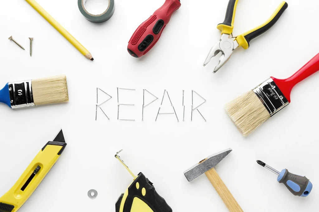 General home repair services concept with tools arranged around the word “repair” spelled from nails.