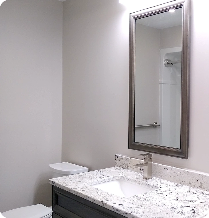 Compact modern bathroom with granite countertop and large framed mirror – Bathroom Renovations Warkworth, ON by Renossance