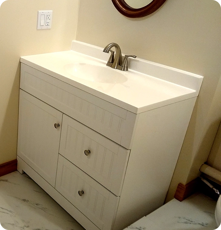 White bathroom vanity with modern faucet and round mirror – Bathroom Renovations Havelock, ON by Renossance