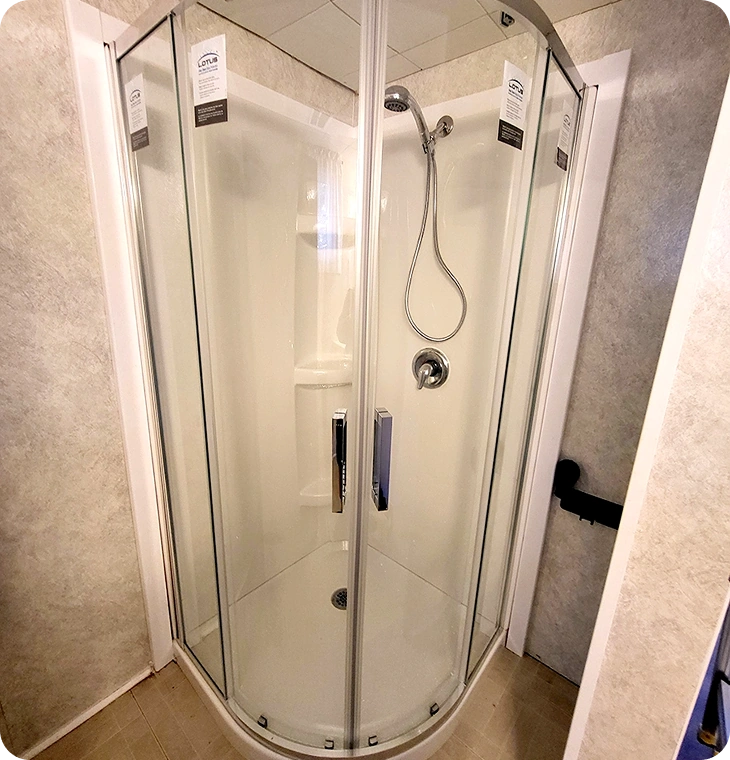 Corner shower unit with curved glass doors and chrome fixtures – Bathroom Renovations Trent Hills, ON by Renossance
