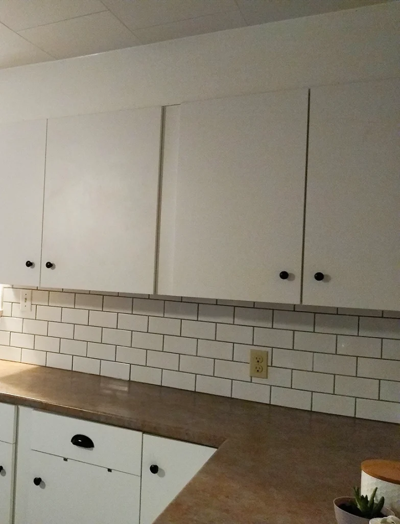White cabinetry and tiled backsplash from a kitchen renovation in Hastings by Renossance.