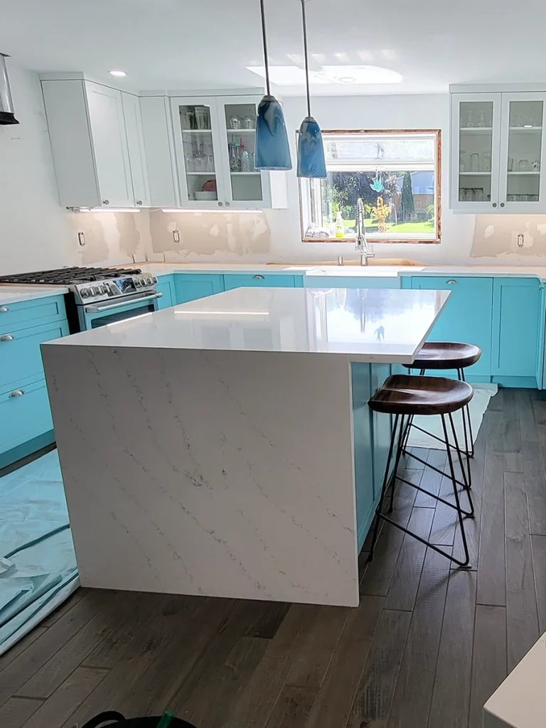 Turquoise cabinets and marble island from a kitchen renovations Warkworth project by Renossance.